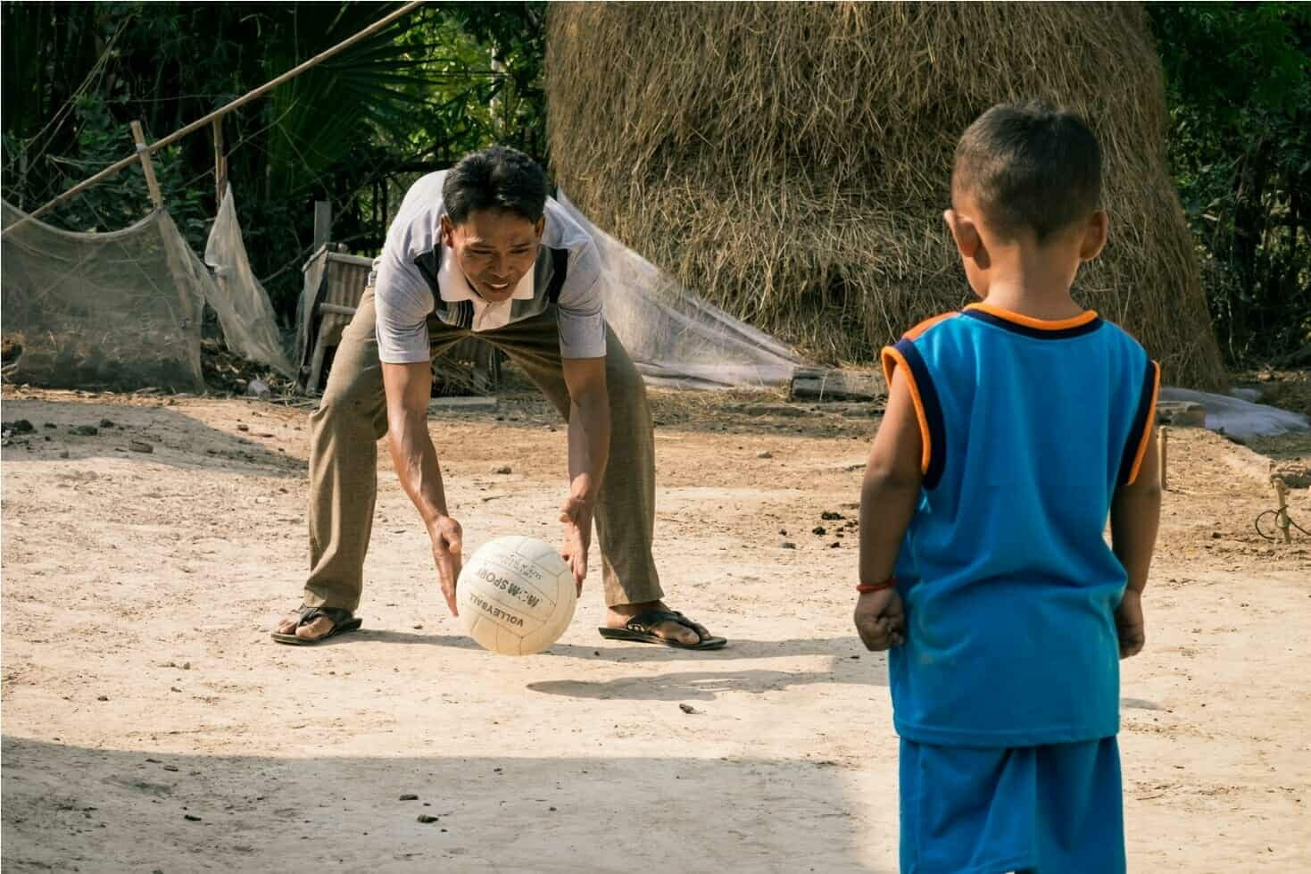 A Children in Families foster father throws a ball to his young son in Cambodia